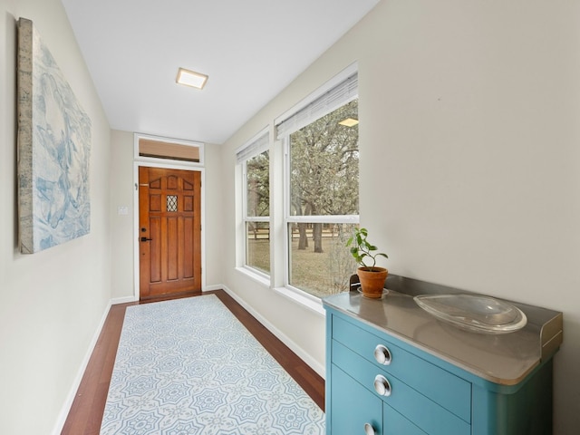 entryway featuring dark wood finished floors and baseboards