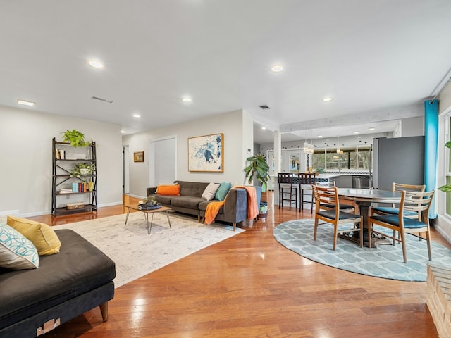 living room featuring baseboards, wood finished floors, visible vents, and recessed lighting