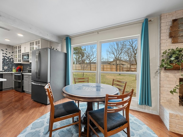 dining area featuring baseboards, visible vents, and wood finished floors