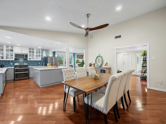 dining room with visible vents, a ceiling fan, lofted ceiling, wood finished floors, and recessed lighting