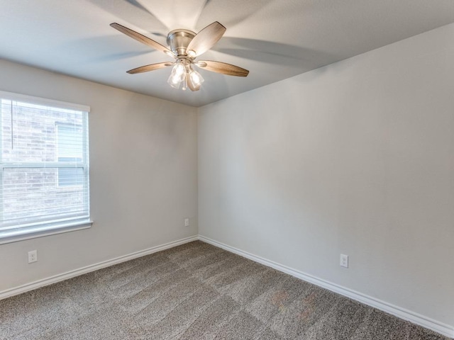 carpeted empty room featuring baseboards and a ceiling fan