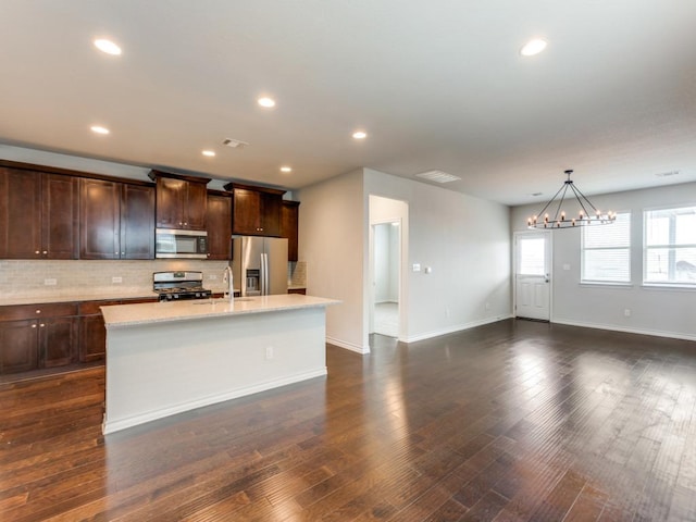 kitchen featuring a sink, a center island with sink, appliances with stainless steel finishes, and backsplash