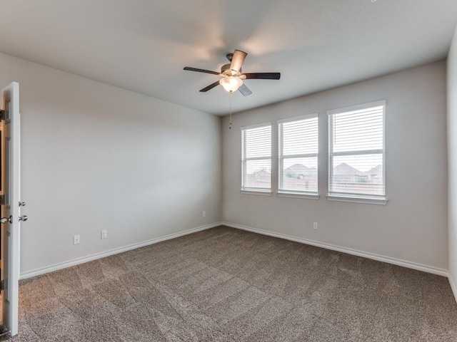 carpeted empty room with baseboards and a ceiling fan