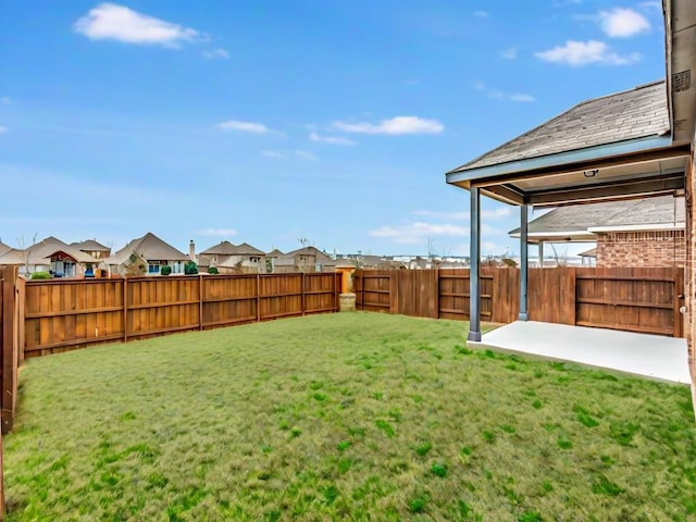 view of yard with a patio, a fenced backyard, and a residential view