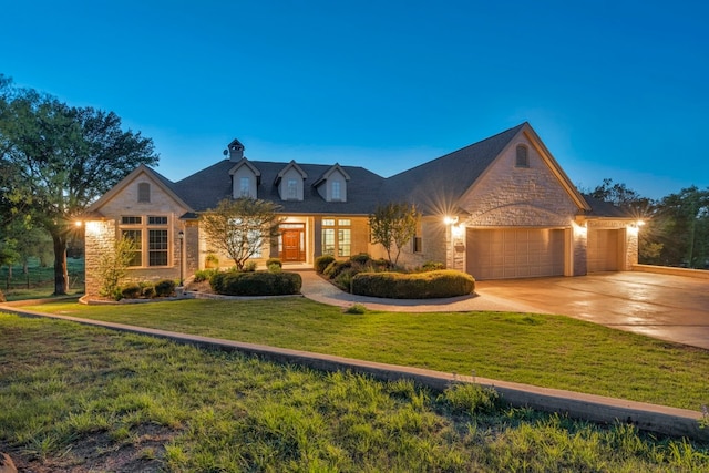 view of front of house with an attached garage, stone siding, concrete driveway, and a front yard