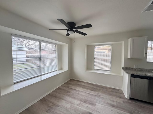 interior space featuring a ceiling fan, visible vents, light wood-style flooring, and baseboards