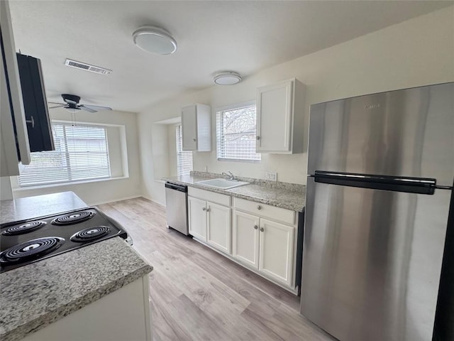 kitchen featuring visible vents, white cabinetry, appliances with stainless steel finishes, light wood-type flooring, and plenty of natural light