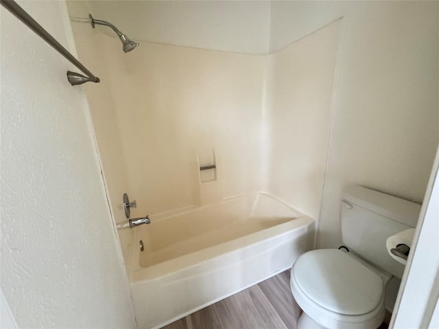 bathroom featuring toilet, shower / tub combination, and wood finished floors