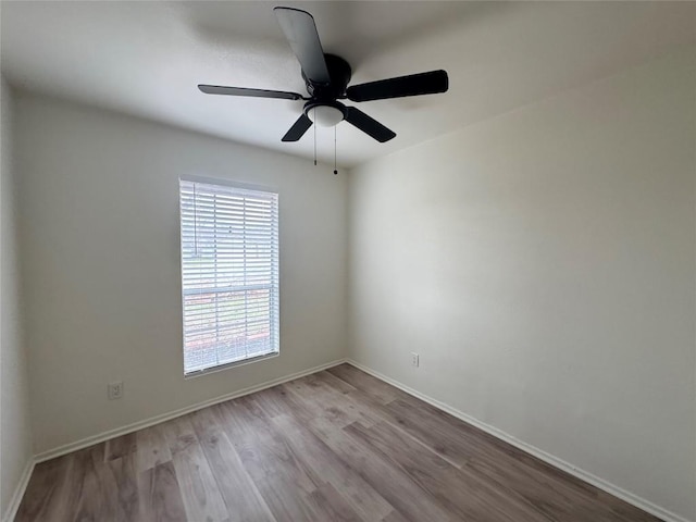 unfurnished room with ceiling fan, wood finished floors, and baseboards