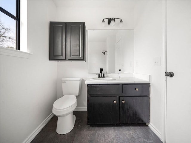 full bath featuring baseboards, vanity, toilet, and walk in shower