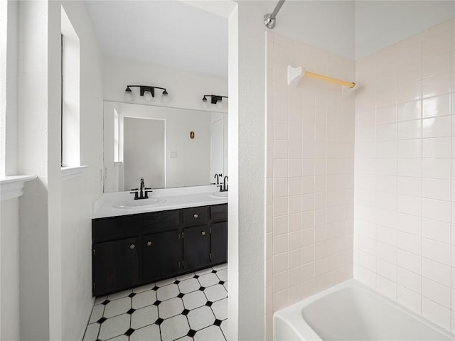 full bath with double vanity, shower / bathing tub combination, a sink, and tile patterned floors