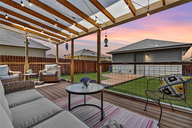 deck at dusk with an outdoor hangout area, a yard, fence, and a pergola