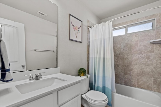 bathroom featuring visible vents, shower / tub combo with curtain, vanity, and toilet