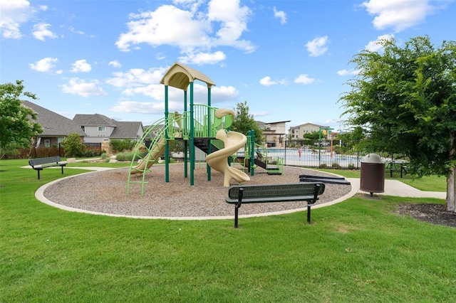 community playground featuring a lawn and fence