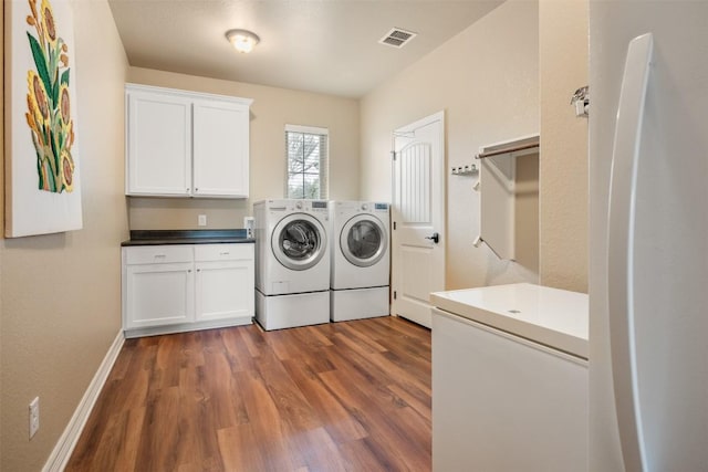 laundry area with cabinet space, baseboards, visible vents, dark wood-style flooring, and washer and dryer