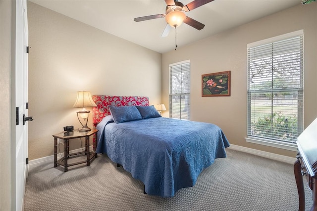 carpeted bedroom featuring multiple windows, baseboards, vaulted ceiling, and a ceiling fan