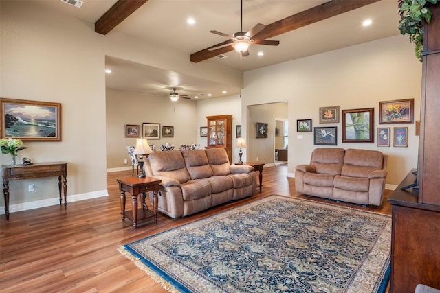 living room with recessed lighting, wood finished floors, a ceiling fan, baseboards, and beamed ceiling