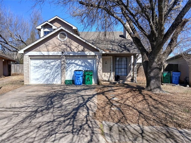 view of front of house featuring a garage, fence, concrete driveway, and brick siding