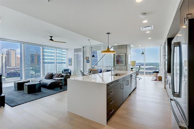 kitchen with floor to ceiling windows, visible vents, appliances with stainless steel finishes, a sink, and modern cabinets