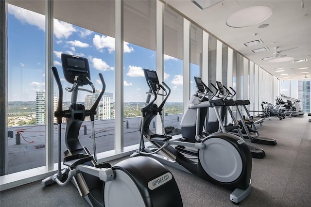 gym with floor to ceiling windows and a city view