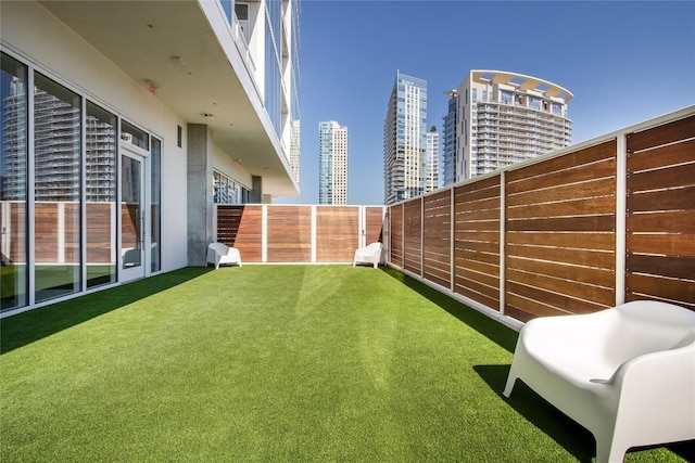 view of yard featuring fence and a city view