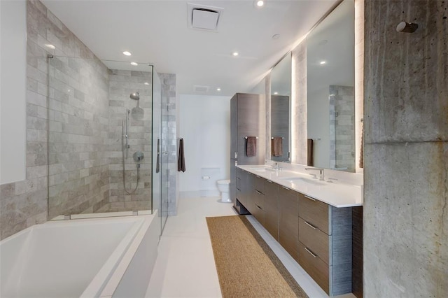 bathroom with toilet, double vanity, a sink, and tiled shower