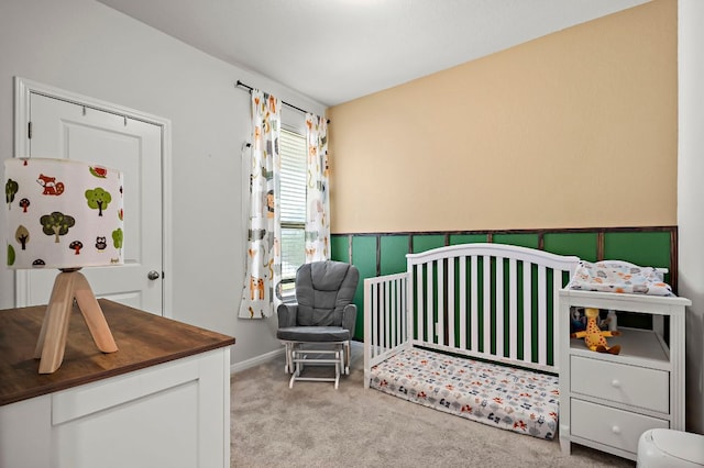 carpeted bedroom featuring a nursery area