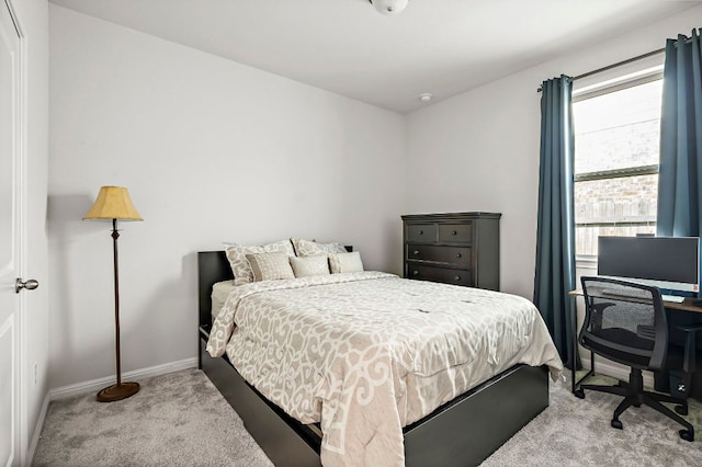 bedroom with light carpet and baseboards