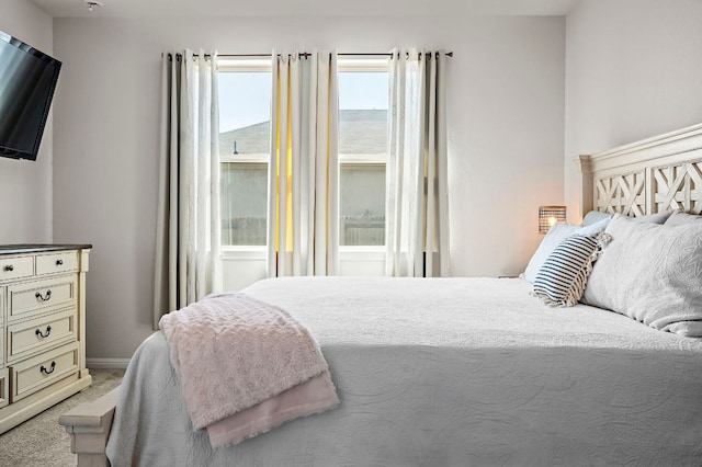 bedroom with light colored carpet and baseboards