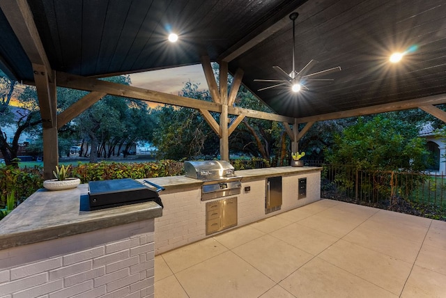 view of patio featuring an outdoor kitchen, a grill, a ceiling fan, and fence