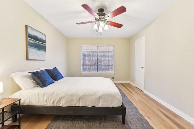 bedroom featuring ceiling fan, baseboards, and wood finished floors