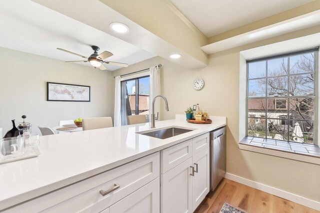 7801 Shoal Creek Blvd Unit 224, Austin, TX 78757 - kitchen featuring a sink, baseboards, light countertops, stainless steel dishwasher, and white cabinets