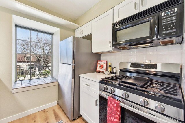 7801 Shoal Creek Blvd Unit 224, Austin, TX 78757 - kitchen featuring stainless steel appliances, light wood-type flooring, backsplash, white cabinetry, and light countertops