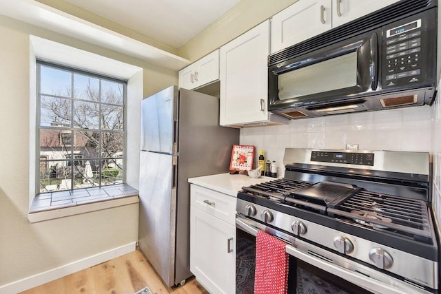 7801 Shoal Creek Blvd Unit 224, Austin, TX 78757 - kitchen featuring stainless steel appliances, white cabinets, tasteful backsplash, light wood-style floors, and baseboards