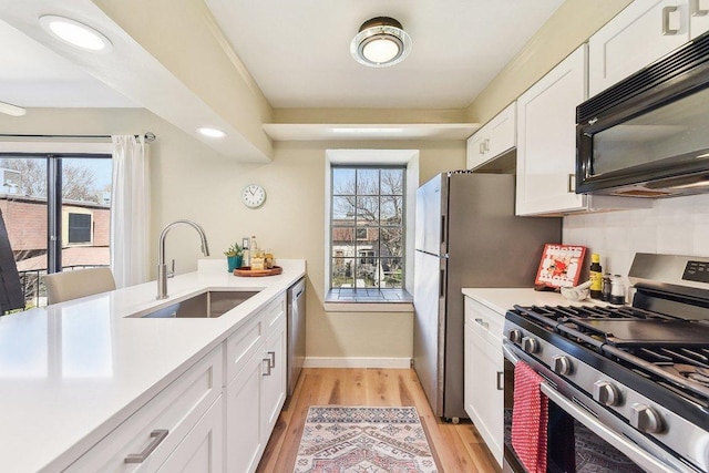 7801 Shoal Creek Blvd Unit 224, Austin, TX 78757 - kitchen with stainless steel appliances, a sink, light countertops, and white cabinetry