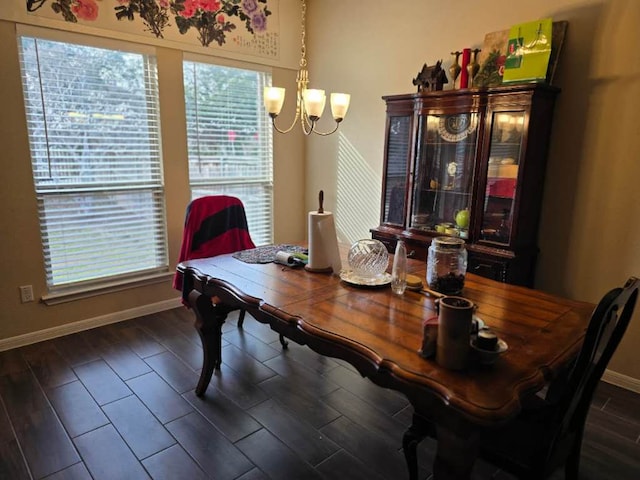 dining room with a notable chandelier, baseboards, and wood finished floors