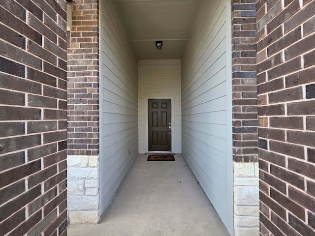 doorway to property featuring brick siding