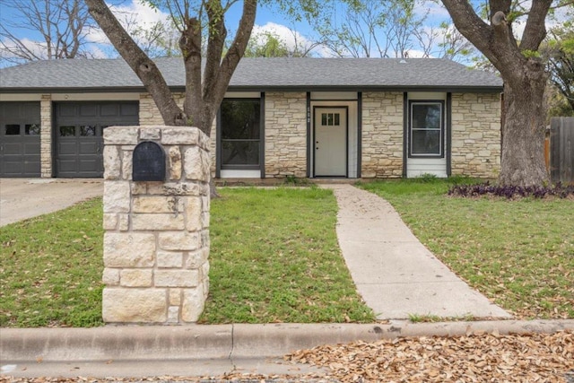 view of front of home with a garage, roof with shingles, concrete driveway, and a front yard