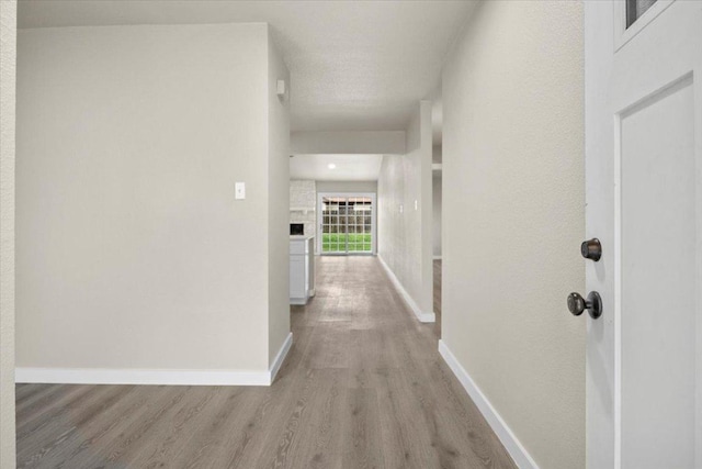 hall with light wood finished floors and baseboards