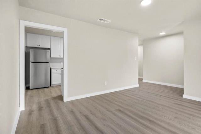 unfurnished room featuring light wood-style floors, baseboards, visible vents, and recessed lighting