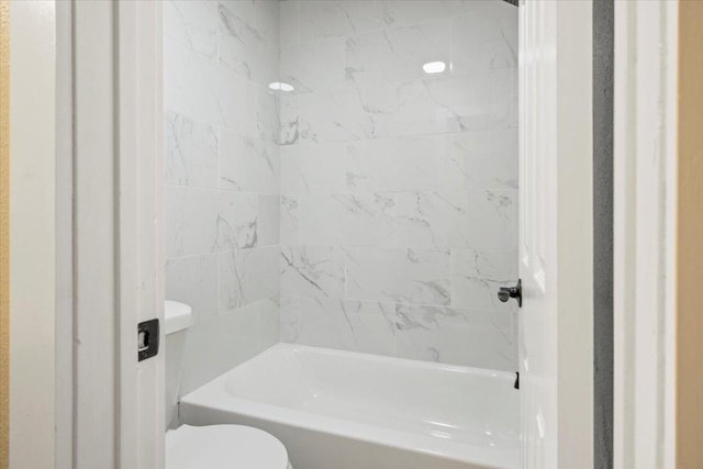 bathroom featuring shower / bathing tub combination and toilet