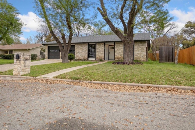 view of front of house featuring a garage, driveway, fence, and a front lawn