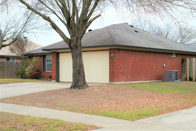 view of property exterior with driveway, central AC unit, an attached garage, fence, and brick siding