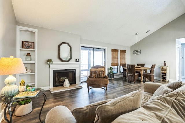 living room featuring baseboards, built in features, a fireplace with raised hearth, lofted ceiling, and wood finished floors