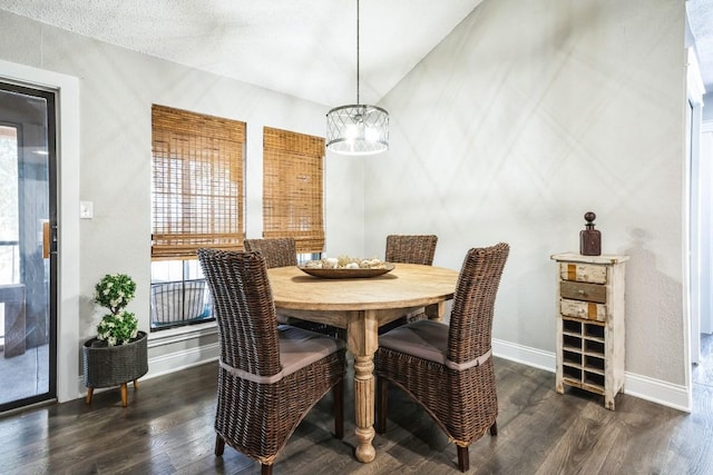 dining area with dark wood-style flooring, a notable chandelier, and baseboards