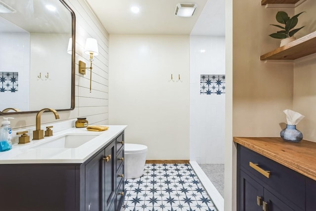 bathroom featuring toilet, walk in shower, vanity, and tile patterned floors