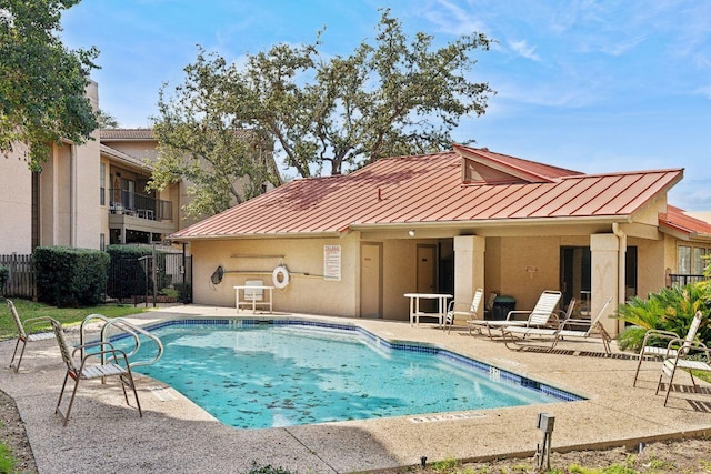 community pool with fence and a patio