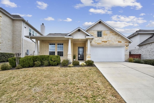 craftsman house with a front lawn, brick siding, a garage, and driveway