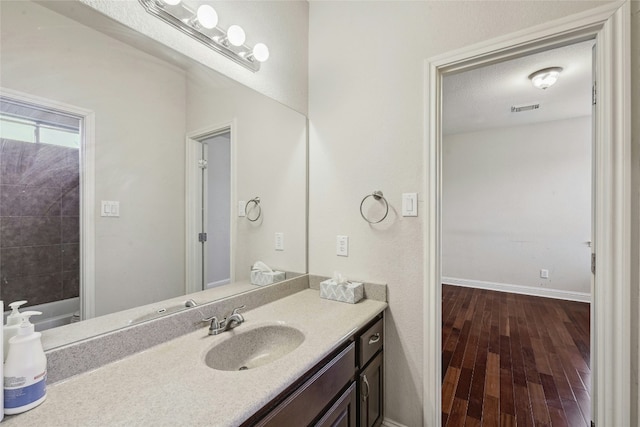 2989 Agave Loop, Round Rock, TX 78681 - bathroom with vanity, hardwood / wood-style floors, baseboards, and a bath