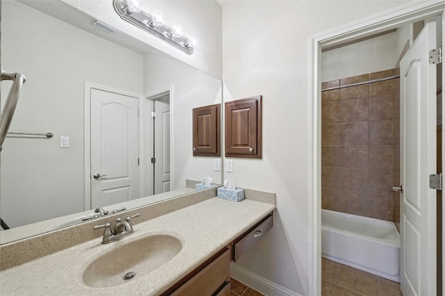 bathroom with visible vents, baseboards, tile patterned flooring, vanity, and washtub / shower combination